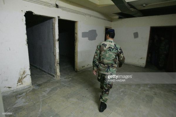A Lebanese soldier walks through cells at the Beau Rivage Hotel bloc, the former headquarters of the Syrian army intelligence (Mukhabarat), who completed their withdrawal from Beirut on March 16, 2005. Photo by Ramzi Haidar/AFP via Getty Images
