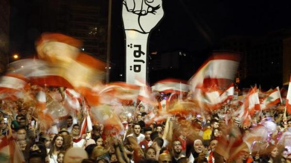 مُتظاهرون مُعارضون للحكومة يُلوّحون بالأعلام اللّبنانيّة خلالَ التظاهرات المناهضة للحكومة في بيروت، لبنان، منظمة هيومن رايتس ووتش ، ۱۰ تشرين الثّاني ۲۰۲۰