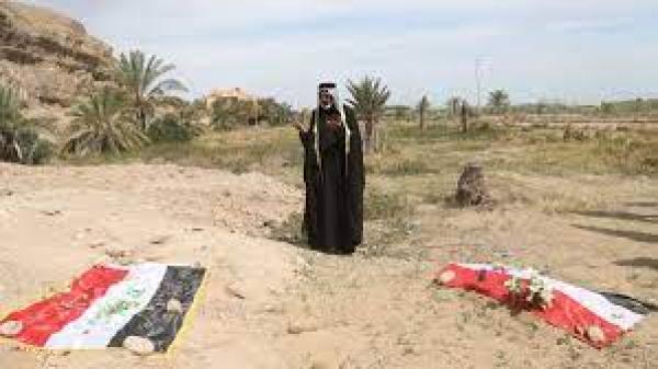 An Iraqi man prays for his slain relative at the site of a mass grave, believed to contain the bodies of Iraqi soldiers killed by ISIL at Camp Speicher on April 3, 2015 [AP/Khalid Mohammed]