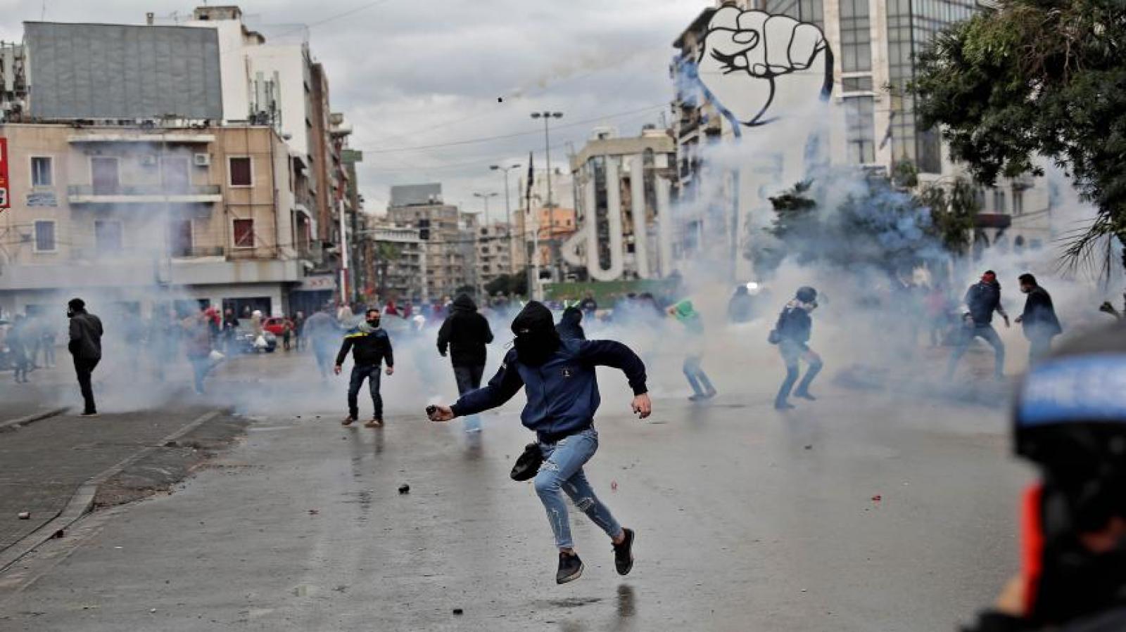 : Anti-government protesters clash with security forces near the Serail (headquarters of the governorate) during a demonstration to protest the economic situation, in the northern port city of Tripoli, Lebanon, Joseph Eid/AFP via Getty Images, January 28, 2021. 