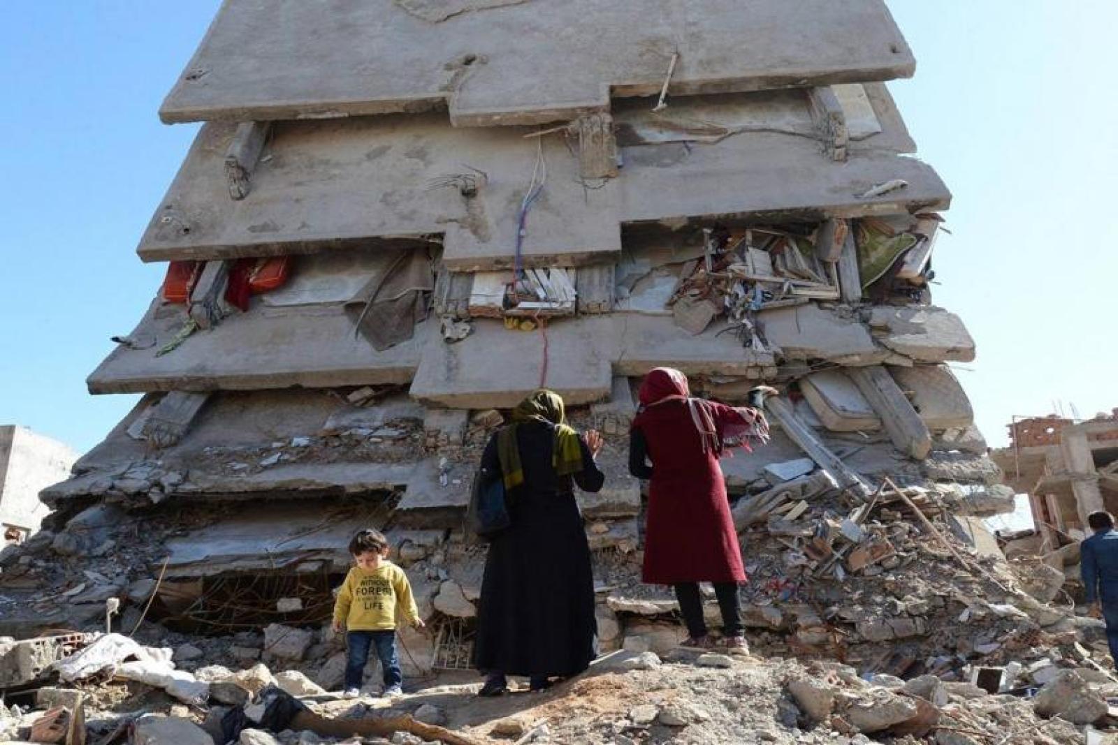 A family standing against ruined building