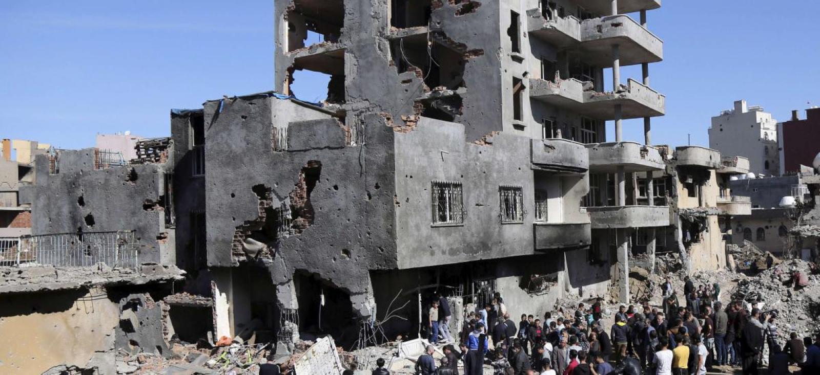 People gather in front of damaged building